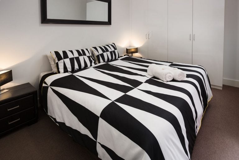 king sized bed in with duvet cover in geometric pattern at star apartments